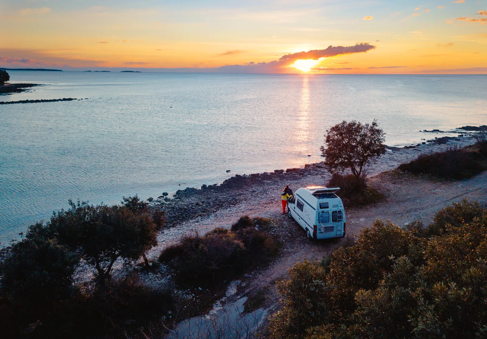 Camper bei Sonnenuntergang am Meer